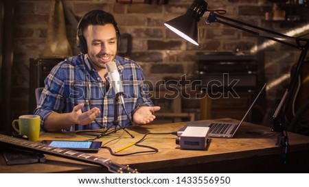 Young man makes a podcast audio recording at home in a garage.
