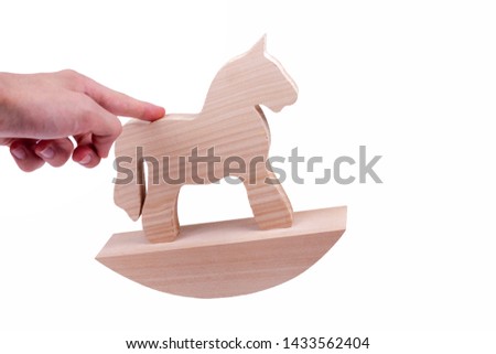 Hand rocking a simple wooden rocking horse toy gesture, figure on a stand. Propelling, moving or putting something in motion business corporate concept isolated on white