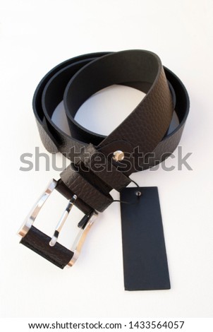 new black leather men's belt on a white background with a black label Royalty-Free Stock Photo #1433564057