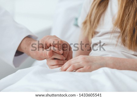 Adult holding hand of a sick child