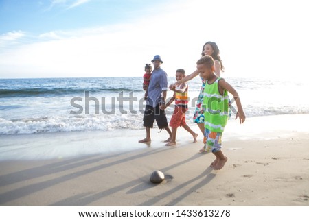 children and their dad with kite at the beach walking