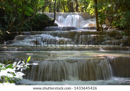 Beautiful scenic of the waterfall and green leaves for refreshing and relaxing background of Huaymaekamin Waterfall in Kanchanaburi, Thailand.