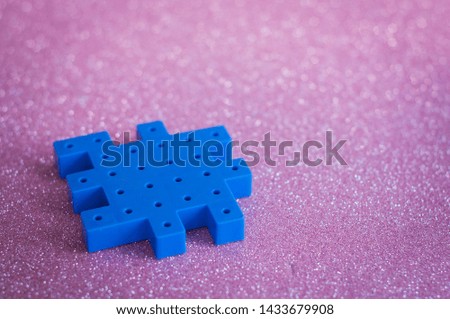 Colorful plastic puzzle pieces on pink Background.