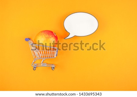 Mango fruit in shopping cart in creative conceptual top view flat lay composition with blank lightbox bubble mock up isolated on bold color background in minimal style with copy space. Pop art poster