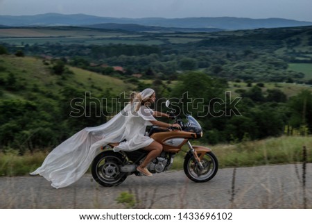 Bride riding a bike through a field of flowers