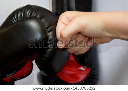 young hand against a boxing glove Royalty-Free Stock Photo #1433705252