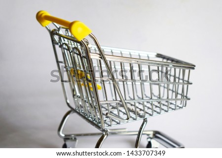 yellow metal shopping trolley whit white background  Royalty-Free Stock Photo #1433707349