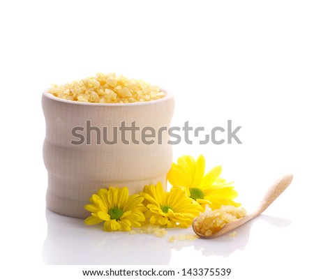 spa still with sea salt in wooden jar and yellow flowers isolated on white