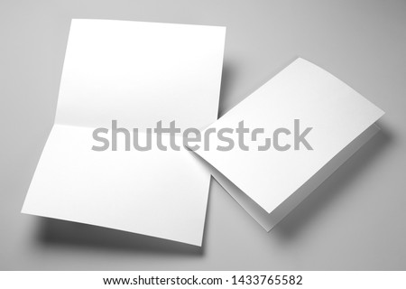 Blank half-folded booklet, postcard, flyer or brochure mockup template on gray background Royalty-Free Stock Photo #1433765582