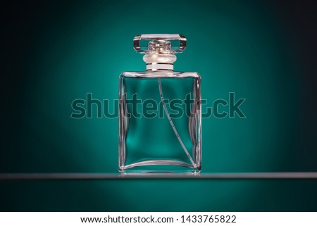 Perfume glass bottle on turquoise background