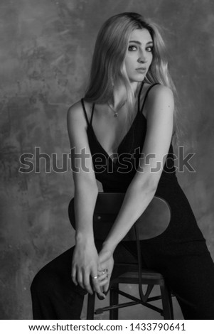 Beautiful slim young woman posing with shoes in the loft studio. Emotions. Black and white