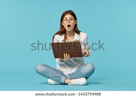 woman in glasses sits with a laptop