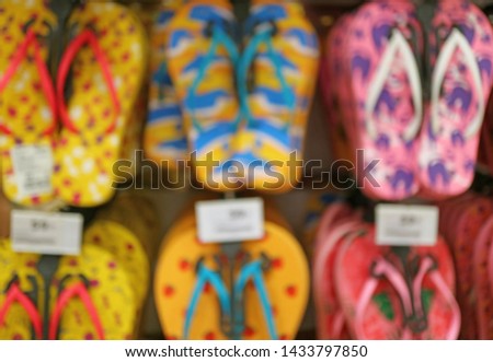 Blurred Image of the Row of Vivid Color Beach Sandals Hanging on the Rack