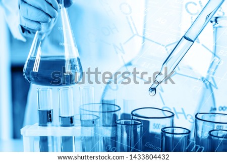 hand of scientist holding flask with lab glassware and test tubes in chemical laboratory background, science laboratory research and development concept