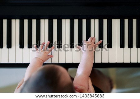 Hands of mother and child  playing piano keyboard top view together, Mother with her daughter learning playing musical instrument, Music lesson school education concept