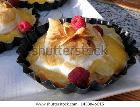 Lemon pie with meringue and raspberries