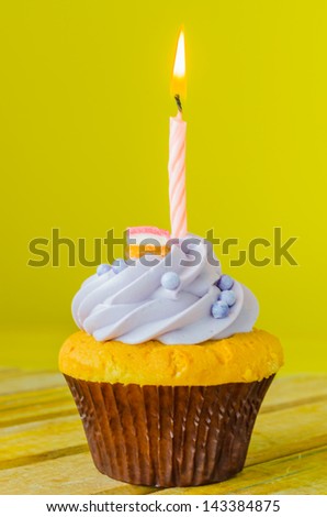 Cupcake with candle on color background