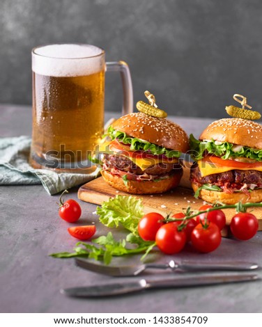 Fresh tasty Craft Burger cooking with beef, tomato, cheese, cucumber and lettuce over grey concrete background