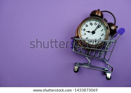 Alarm clock and Mini trolley cart with space copy on purple background