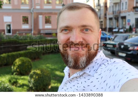 Selfie portrait of an adult bearded man on the background of the old city. Photos from the trip.
