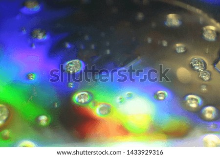 Close up view of iridescent soap bubbles on mirror surface. Rainbow holographic effect: refraction causes the dispersion of white light into color spectrum,  seven main colors, constituent hues.