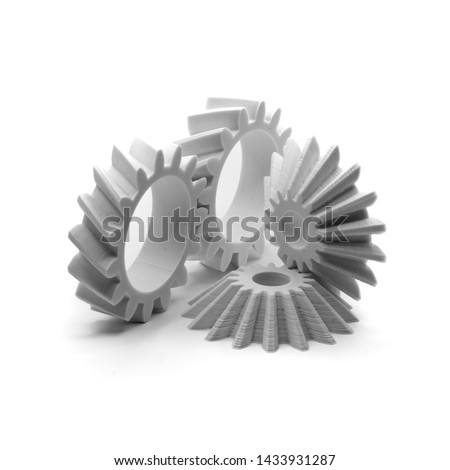 Fused Deposition Modelling (FDM) 3D printed helical and bevel gears printed in white PLA on a white backdrop