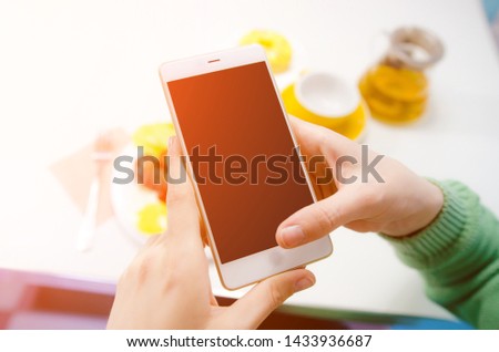 Close up of women's hands holding cell telephone with blank copy space screen. Selective focus, closeup
