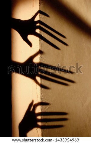 Strange Shadow On The Wall.Terrible Shadow. Abstract Background. Black Shadow Of A Big Hand On The Wall. Silhouette Of A Hand On The Wall. Nightmares. Scary Dreams.
