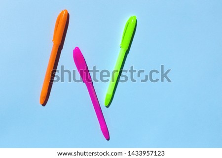 Neon colorful pen on blue background. 
 Copy space for your text. Flat lay, top view. 