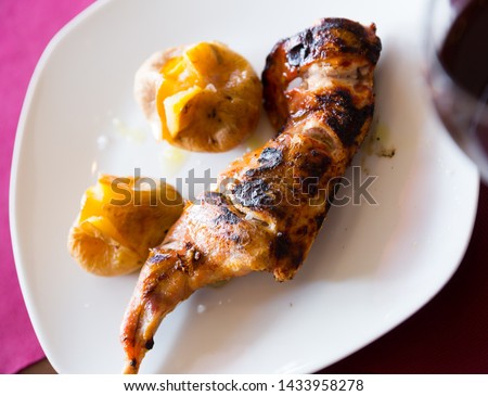 Picture of tasty baked quarter of  rabbit, served with pototoes at plate