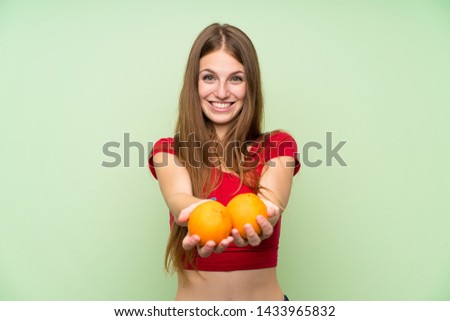 Young woman with long hair holding an orange