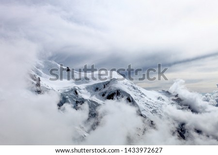 Mont Blanc Covered with snow and clouds. Single mountain peak. Snowy mountain summit. White mountain top on a cloudy day. Snow-covered white mountain peak. Mountains landscape. Climbing mountains. Royalty-Free Stock Photo #1433972627