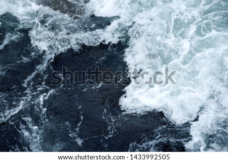  waves with foam in the dark blue water Royalty-Free Stock Photo #1433992505