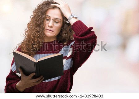 Young brunette girl reading a book wearing glasses over isolated background stressed with hand on head, shocked with shame and surprise face, angry and frustrated. Fear and upset for mistake.