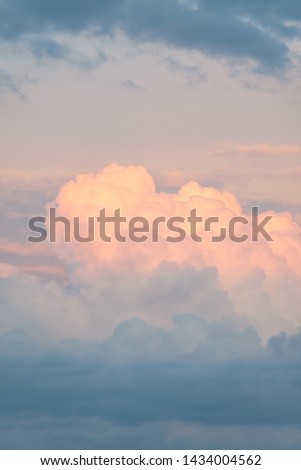 Portrait photo of big, pink cumulonimbus clouds in a stormy sky at sunset. Shot in Montreal, Quebec, Canada. 