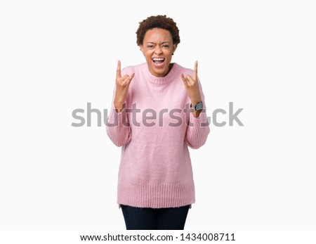 Beautiful young african american woman over isolated background shouting with crazy expression doing rock symbol with hands up. Music star. Heavy concept.