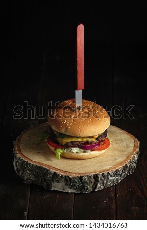 Homemade burger with fork on rustic wood background close up