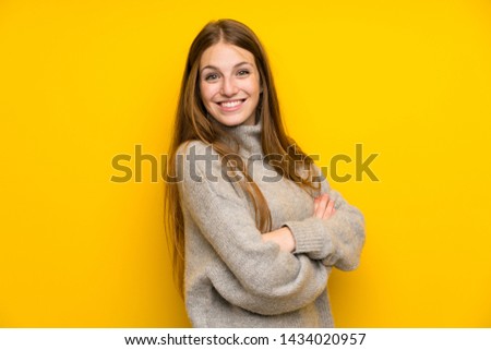 Young woman with long hair over yellow background laughing