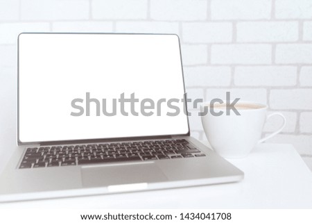 Mock up concept of remote work, downshifting using laptop with blank white desktop screen with a cup of coffee
