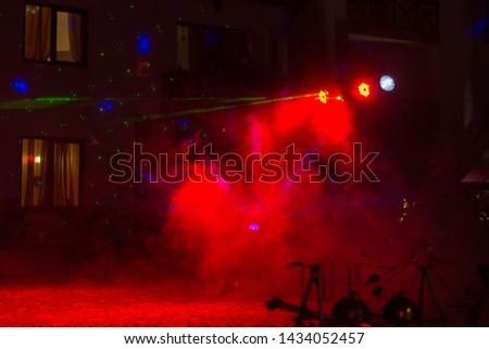 Scene in red smoke with rays of spotlights.