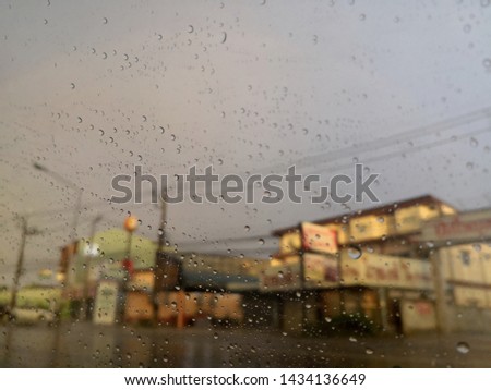 Cloudy rainy day in summer in hatyai city ,Images of rain drew background due drops on car glass.drops on window glass and cityscape.