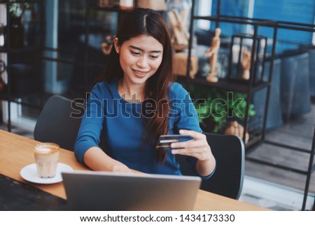 Attractive young Asian woman working with laptop in co-working space.