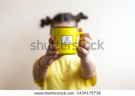 A girl in a yellow T-shirt with a yellow ring in her hand, on which was written Did you know. Interesting fact