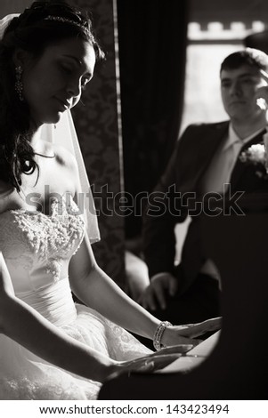 Newlyweds. Bride playing piano