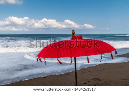 Red beach umbrella by the shore 