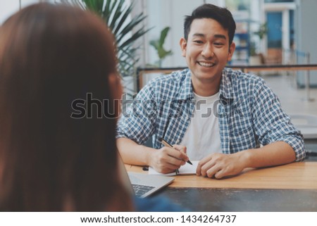 Two Asian woman and Asian man working together at co-working space.
