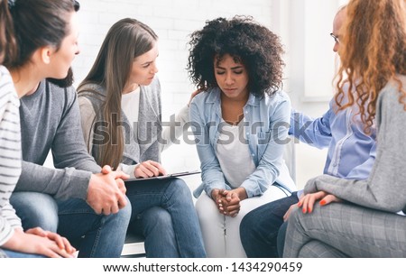 Understanding people giving support to depressed crying african woman at group psychological treatment, free space Royalty-Free Stock Photo #1434290459