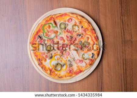 homemade crispy pizza with cheees,tomatoes and olives on wooden table, top view and copy space