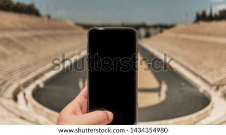 Travel concept - tourist taking photo with smart phone in a sunny day in the capital of Greece - Athens