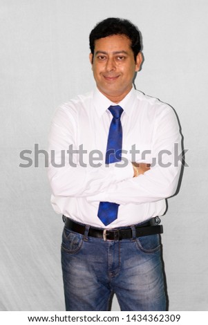 Portrait of young business man wearing office dress and blue tie , studio shot on white background.